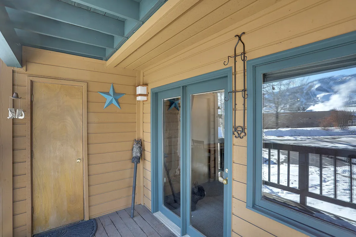 The interior entry space of the condo, featuring charming star decorations, double glass doors, and a wooden door. The area exudes warmth, signaling the transition from outdoor adventures to comfortable family living.